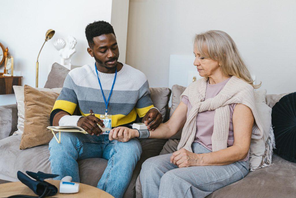A healthcare provider checking the blood pressure of a menopausal woman.