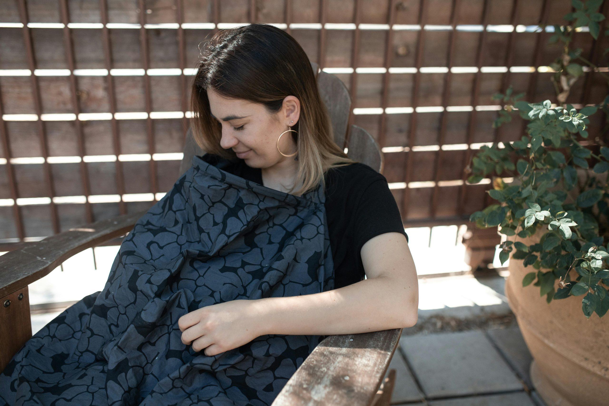 Woman breastfeeding with a cover