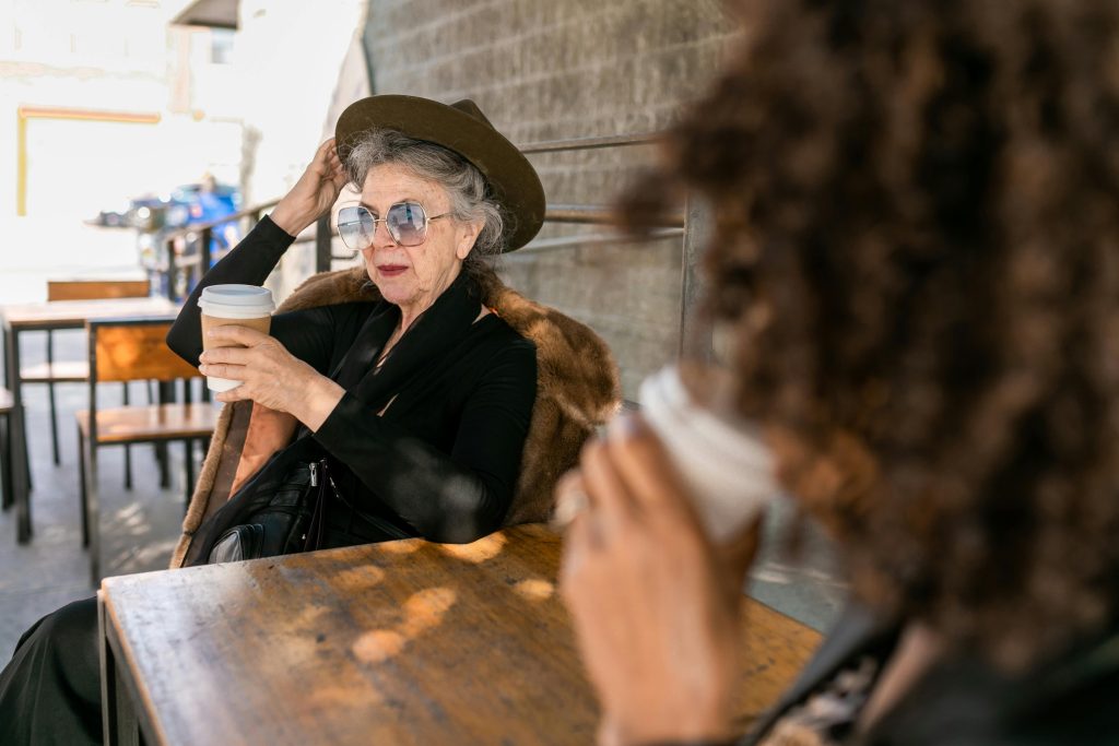Two older women having a coffee sitting at a table