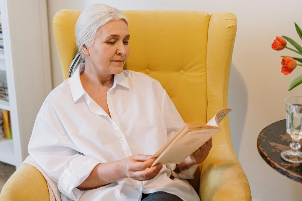 Older woman reading a book in a chair